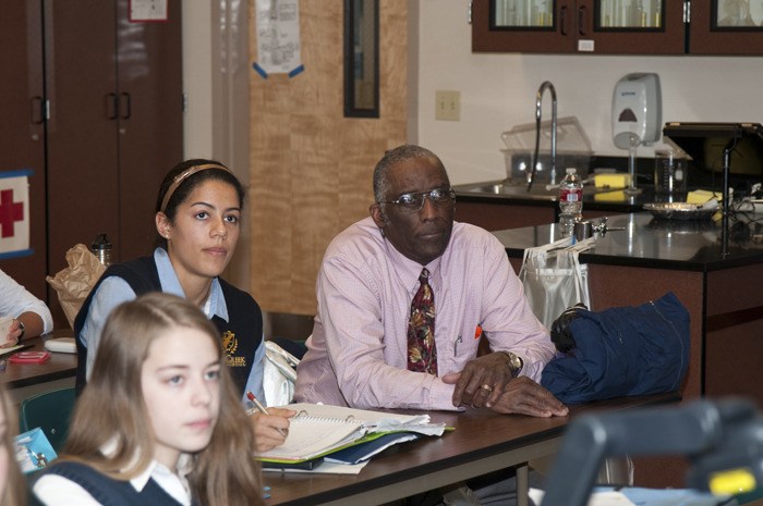 Madelyn Maggie takes notes during AP Chemistry class while her grandfather John Magee looks on. During the campus tour