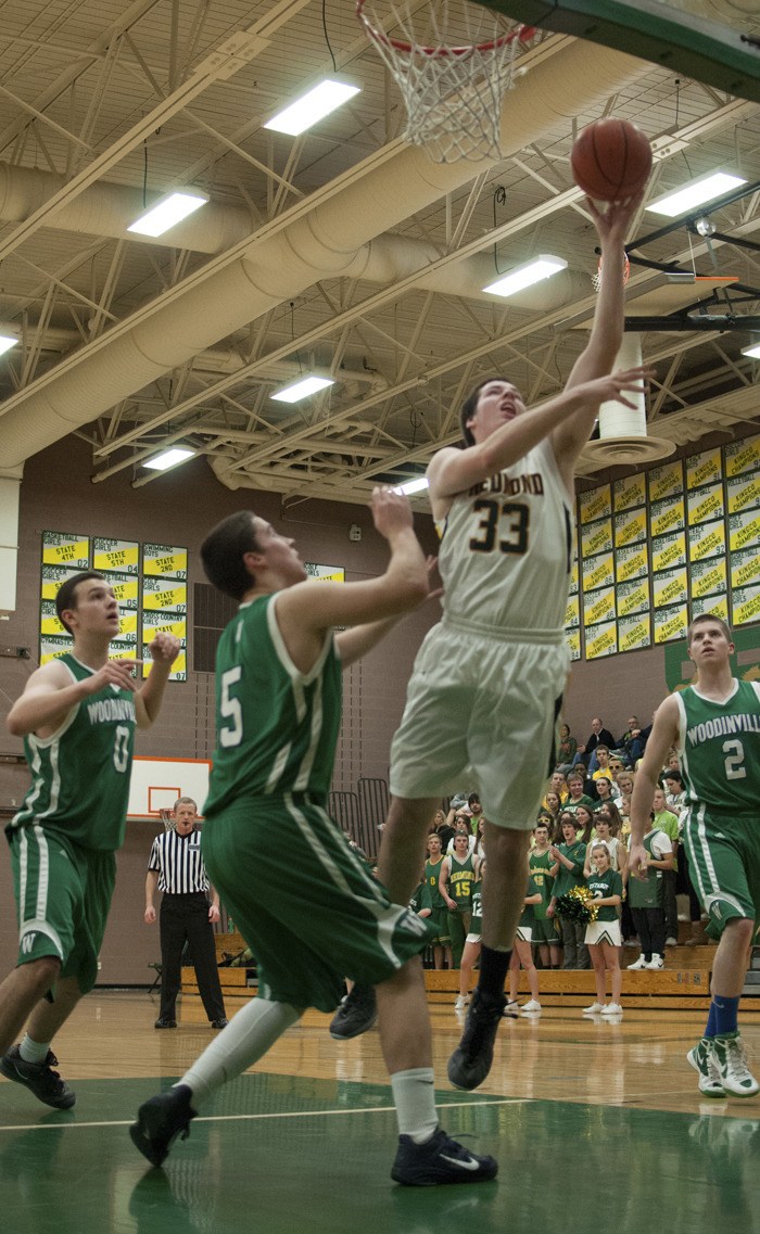 Redmond High senior Conner Floan goes up for two of his 15 points during the Mustangs’ 65-43 win against Woodinville Tuesday night. Redmond has won five straight games and moved within a half-game of the division lead.