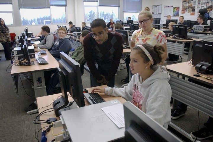 TEALS instructor and Microsoft Corp. employee Robert Goins (left) helps sophomore Cori Meyers on an in-class assignment during a computer science class at Lake Washington High School