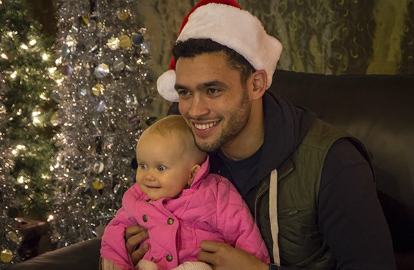 Seattle Sounders FC forward Lamar Neagle poses with 1-year-old Emelia Atkinson at the Volume 12 store last Friday night during Redmond Town Center's Celebrity Santa Night. Proceeds from the photos benefit The Neagle Foundation