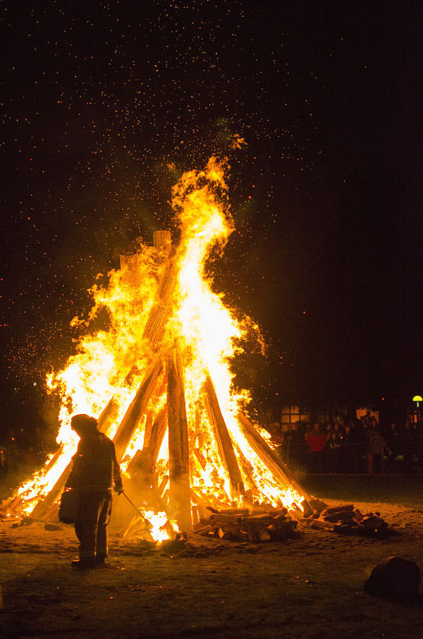 A firefighter keeps the bonfire going last Sunday evening at Redmond City Hall. About 2