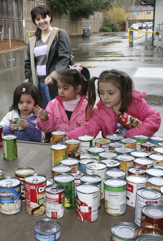 Christina Lu watches as her preschool daughter Janae Lu (left) helps big sister Jasmine Lu and Kaitlyn Winter