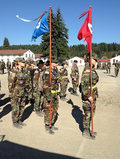 Cadet Capt. Joanna Aponte of Kirkland holds the blue guidon flag at basic training encampment for new cadets at Joint-Base Lewis-McChord. It is an honor to be selected to carry the guidon flag.