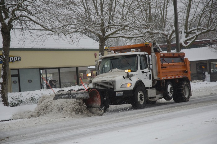 A City of Redmond snow plow clears the streets during Wednesday's snow fall. Conditions are still icy and snowy and the Redmond Police Department is encouraging all residents to stay off the roads.