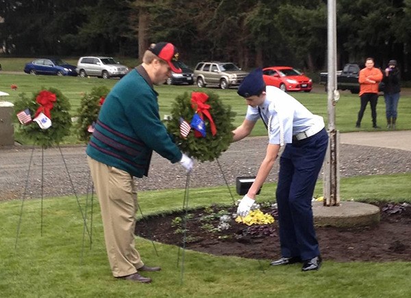 Air Force veteran Harris Helgeson (accompanied by a Civil Air Patrol cadet) places a wreath in honor of the United States Air Force during the national Wreaths Across America event last Saturday at Cedar Lawns Memorial Park and Cemetery in Redmond.