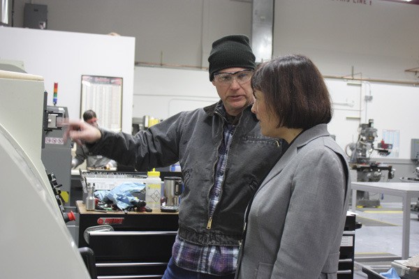 Miles Johansen (left) shows Rep. Suzan DelBene some of the machinery they work with at B.E. Meyers Electro Optics in Redmond.