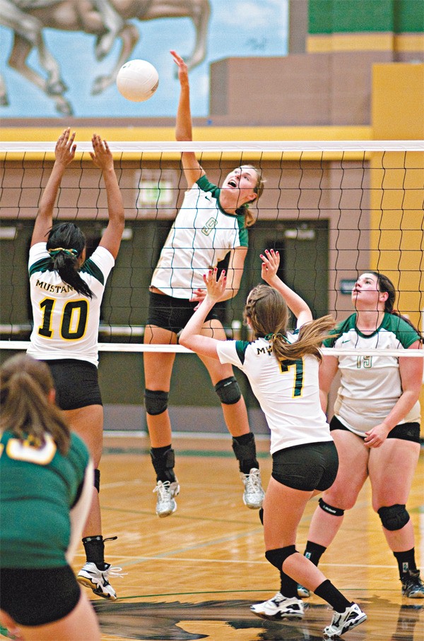 Senior Elizabeth Fernandez (No. 9) of Bear Creek spikes the ball as Redmond's Heather Smith (No. 10) and Ali Henderson (No. 7) defend during the Grizzlies' 3-0 sweep at Redmond High on Tuesday night. They also swept Tacoma Baptist last night to improve to 6-1-1 on the young season.