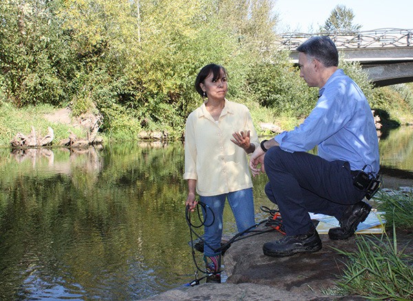 Debra Bouchard (left) discusses with Dow Constantine how they measure river water temperatures.