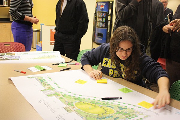 Deborah Benaloh adds her comments to one of the park plans presented at the community meeting Wednesday evening at Redmond City Hall.