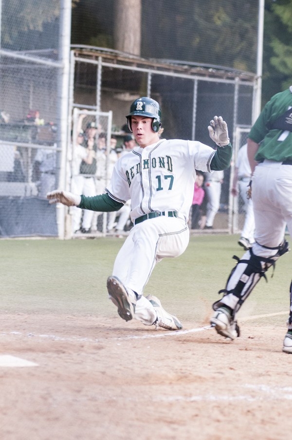 Redmond High School senior Peter Hendron slides home safely during the Mustangs' 12-8 comeback win against Skyline Monday night. Hendron scored three times as Redmond won its 11th straight game.