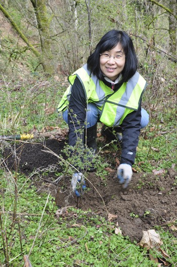 Justine Pfaffe of Waste Management admires her newly planted shrub.