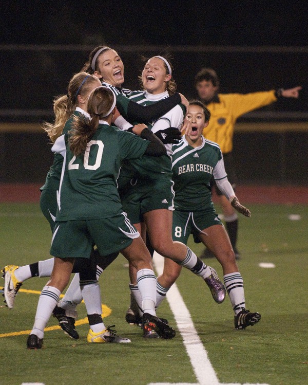 Bear Creek players mob senior Morgan Rial (second from right) after she scored the game-winning goal in the 77th minute of last night's Tri-District soccer game