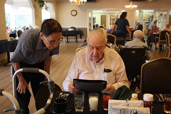 Khanh Cung (left) waits to hear what Victor Hyslop would like to have for lunch at Redmond Heights Senior Living.