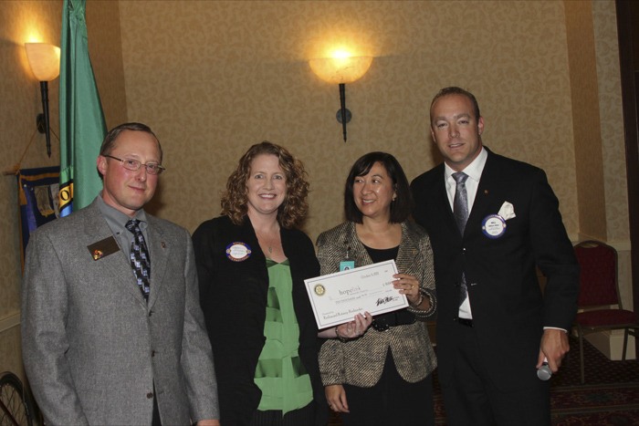 Rotary Club of Redmond President Steve Bozick (left) and 2010 RedsSpoke chair Will Miller (right) presented Meghan Altimore and Lauren Thomas of Hopelink with a $10