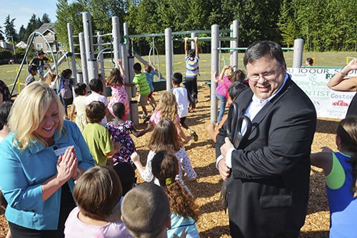 Lake Washington School District Superintendent Dr. Traci Pierce and Mayor John Marchione make way for Redmond Elementary students surging onto the new playground after the ribbon was cut on Aug. 28.