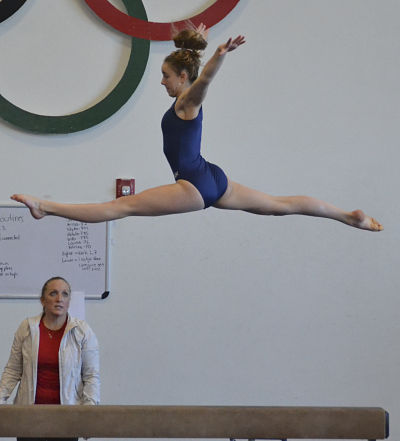 Marisa Savage soars high above the beam during a recent gymnastics competition.